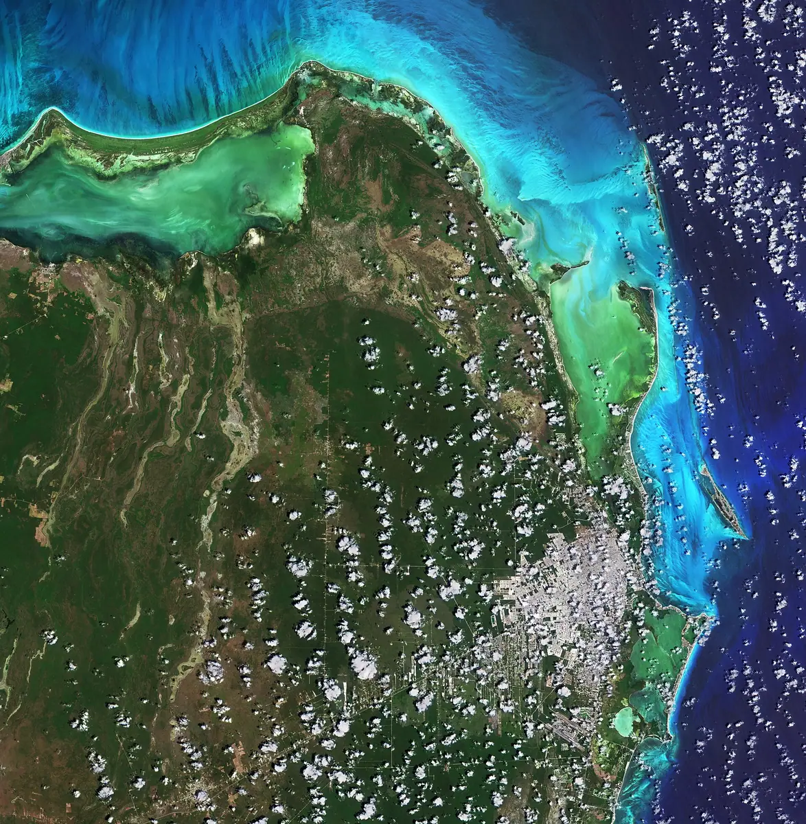 坎昆：Cancún, situated in Quintana Roo on the northeast coast of Mexico’s Yucatán Peninsula, is featured in this image captured by the Copernicus Sentinel-2 mission. Cancún’s location on the Caribbean Sea, tropical climate and string of beaches have made the city and the Riviera Maya to the south of Cancún one of Mexico’s top tourist destinations. In this image, captured on 16 April 2021, the city can be seen in the bottom-right corner, shrouded in clouds. Cancun International Airport, Mexico’s second busiest airport, is located around 20 km south of the city. The Cancún Island resort area, visible just off the coast, is shaped like the number seven and is around 22 km in length. The island is separated from the city by the Nichupté Lagoon but is linked by two causeways at each end. Most of the tourist industry is centred on Cancún Island with its Caribbean-facing beaches. Isla Mujeres, Spanish for ‘Island of Women,’ is visible just north of Cancún Island and is most famous for its beaches and snorkelling. Isla Contoy, visible in the top-right of the image, is considered one of the most important nesting places for sea birds in the Mexican Caribbean with more than 150 species of birds. Quintana Roo covers an area of around 42 000 sq km and is home to several protected areas including the El Eden Ecological Reserve, located 50 km northwest of Cancún, and Yum Balam Flora and Fauna Protected Area, located in the north of the state. Encompassing more than 150 000 hectares, Yum Balam is home to several endangered species including jaguars, crocodiles and monkeys. The colour of the water in the image varies from emerald green to turquoise owing to the changing water depths along the coast, turbidity and differences on the ocean floor – from sand to seaweed to rocky areas. With its 13 spectral channels, Copernicus Sentinel-2’s novel imager can capture water quality parameters such as the surface concentration of chlorophyll, detect harmful algal blooms, and measure turbidity (or water clarity) – giving a clear indication of the health and pollution levels. This image is also featured on the Earth from Space video programme. Credits: contains modified Copernicus Sentinel data (2021), processed by ESA, CC BY-SA 3.0 IGO